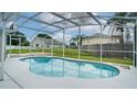 Sparkling in-ground pool surrounded by a screened enclosure and lush landscaping, perfect for relaxation at 611 Jura Ln, Kissimmee, FL 34759