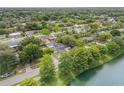 Aerial view of a lovely neighborhood with mature trees and a home with a swimming pool bordering a lake at 614 S Amelia Ave, Deland, FL 32724