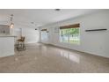 Bright living room with terrazzo floors, a white interior, and natural light streaming through the windows at 614 S Amelia Ave, Deland, FL 32724
