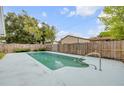 In-ground pool surrounded by a wood fence in the backyard of this home at 614 S Amelia Ave, Deland, FL 32724