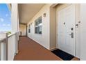 Welcoming hallway featuring a door with a secure lock, exterior lighting, and a glimpse of outdoor scenery at 7509 Mourning Dove Cir # 302, Reunion, FL 34747