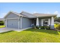 Well-maintained single-story home featuring gray exterior, landscaping and charming front entrance at 9020 Se 42Nd Ct, Ocala, FL 34480