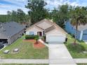 Inviting one-story home featuring a two-car garage, landscaped front yard, and a charming entrance at 917 Dekleva Dr, Apopka, FL 32712