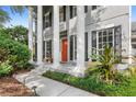 Inviting front porch with stately pillars, black shutters, a cozy bench, and well-maintained landscaping at 11425 Claymont Cir, Windermere, FL 34786
