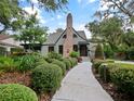 Quaint home featuring immaculate landscaping, a brick chimney, and a garden at 1227 Golden Ln, Orlando, FL 32804