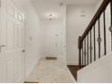 Bright entryway with tiled floors, coat closet, and staircase with wrought iron railings at 1277 Blessing St, Maitland, FL 32751