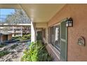 Exterior of condo unit with green shutters, mature landscaping, and access to a walkway at 145 Oyster Bay Cir # 140, Altamonte Springs, FL 32701