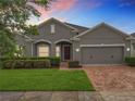 Charming single-story home featuring a well-manicured lawn and a brick-paved driveway at 1540 Orange Valley Rdg, Ocoee, FL 34761