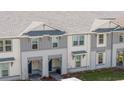 Up close view of townhomes showcasing white and gray tones, covered entryway, and meticulous landscaping at 16061 Blue Wave Way, Clermont, FL 34714