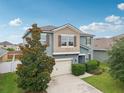 Two story home with a beige two-car garage, manicured landscaping, and a decorative tree in the front lawn at 16440 Centipede St, Clermont, FL 34714