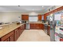 A kitchen featuring wood cabinets, granite countertops, stainless steel appliances, and a breakfast bar at 2017 W Gore St, Orlando, FL 32805