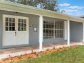 Attractive front porch with white columns, double doors, and stone walkway, enhanced by colorful landscaping at 2050 Anne Cir, South Daytona, FL 32119