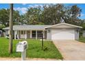 Well-maintained home featuring a mailbox and green lawn, complemented by a paved driveway and garage at 2050 Anne Cir, South Daytona, FL 32119