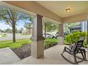 Inviting front porch featuring neutral toned columns and a comfortable rocking chair at 2604 Bullion Loop, Sanford, FL 32771