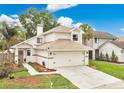 Charming two-story home featuring a two-car garage, lush landscaping, and inviting front entrance at 345 Goldstone Pl, Lake Mary, FL 32746
