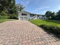 Inviting property featuring a brick driveway leading up to a beautiful home with a well-maintained lawn and welcoming facade at 3702 Mirror Lake Dr, Apopka, FL 32703