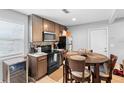 Eat-in kitchen with wood cabinets, black appliances, and a cozy dining table for casual meals at 3824 Johnson St, Orlando, FL 32805
