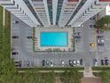 Aerial shot of a modern pool surrounded by a parking area, greenery, and walkways, blending urban living with leisure at 400 E Colonial Dr # 1103, Orlando, FL 32803