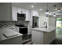 Modern kitchen features white cabinets, stainless steel appliances, and quartz countertops at 508 Bennett St, Auburndale, FL 33823