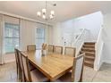 Bright dining room features a large wooden table, elegant chandelier, and a staircase to the upper level at 5255 Wildwood Way, Davenport, FL 33837