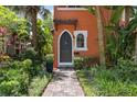 Charming home entrance with arched front door, brick walkway, and vibrant, meticulously cared-for landscaping at 602 E Livingston St # 3, Orlando, FL 32803