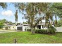 Beautiful property with white brick exterior, black shutters, and green lawn in a suburban neighborhood at 7307 Grace Rd, Orlando, FL 32819