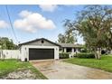 Attractive home showcasing a white brick exterior, black garage door, and well-maintained lawn at 7307 Grace Rd, Orlando, FL 32819