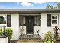 Elegant front entrance with a decorative black door, patterned tile landing, and white brick exterior at 7307 Grace Rd, Orlando, FL 32819