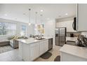 Bright, open kitchen featuring a central island, stainless steel appliances, and modern pendant lighting at 746 Longboat Dr, Davenport, FL 33896