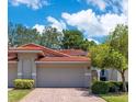 Charming villa showcasing a red tile roof, lush landscaping, and a well-maintained exterior at 8035 Bayside View Dr, Orlando, FL 32819