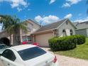 Exterior view of a home with a brick driveway and well-maintained landscaping at 807 Knightsbridge Cir, Davenport, FL 33896