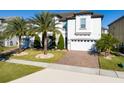 Inviting two-story home featuring a brick driveway, well-kept lawn, and a two-car garage at 8085 Ludington Cir, Orlando, FL 32836