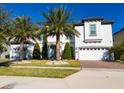 Attractive two-story home boasting a brick driveway, green lawn, and a two-car garage at 8085 Ludington Cir, Orlando, FL 32836
