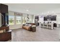 Spacious living room features hardwood floors and connects to a modern kitchen with breakfast bar at 8975 Fluffy Lie Ct, Davenport, FL 33896