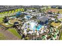 Aerial view of community pool and waterpark area with manicured landscaping, lounge areas, and ample parking at 8975 Fluffy Lie Ct, Davenport, FL 33896