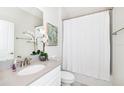 Clean and modern bathroom with a stylish vanity, framed art, and shower with white curtain at 9106 Cut Shot Dr, Winter Garden, FL 34787
