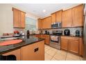 Well-lit kitchen features stainless steel appliances, granite countertops, and light wood cabinets at 9539 Silver Buttonwood St, Orlando, FL 32832