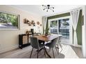 Dining room with modern light fixture, large window, and view of pool at 105 Bilsdale Ct, Longwood, FL 32779