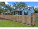 Charming blue home with a wooden fence and manicured lawn at 1407 S Palmetto Ave, Sanford, FL 32771