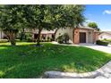 Charming single-story home featuring a well-manicured lawn, mature trees, and a brick-accented garage at 154 Golf Club Dr # 154, Longwood, FL 32779