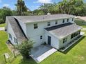 Rear exterior view of a house with gray roof, patio, and fenced in yard at 1836 Se 6Th Ave, Ocala, FL 34471