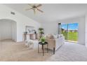 Bright living room with neutral walls and carpet, featuring a comfortable sofa and sliding glass doors to the backyard at 200 Cimarron Dr, Kissimmee, FL 34759