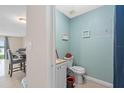 Half bathroom with a toilet, a sink with white cabinets, light-blue walls, and decor at 214 Majors Ln # B, Kissimmee, FL 34743