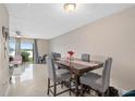 Inviting dining room with sleek tiled floors, an elegant table setting, and sliding glass doors leading to the screened patio at 214 Majors Ln # B, Kissimmee, FL 34743