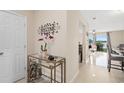 Bright entryway featuring a decorative welcome sign, glass table, and a glimpse into the living area with views of the lake at 214 Majors Ln # B, Kissimmee, FL 34743