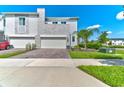 Modern townhome with a two-car garage, stone accents, and well-maintained landscaping, perfect for stylish living at 224 Nine Iron Dr, Davenport, FL 33896