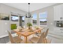 Inviting dining area with a sliding glass door, modern lighting, and seating for six at 2311 Bear Peak Rd, Clermont, FL 34715