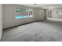 Neutral living room with carpet and large windows, offering a view of the backyard pool at 2710 Wyndham Ln, Orlando, FL 32808