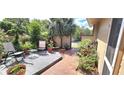 Private outdoor living space featuring a gray wooden deck, brick walkway and lush plants at 2922 Burlington Dr, Apopka, FL 32703