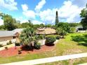 Inviting single-story home surrounded by lush greenery, palm trees and vibrant landscaping at 2922 Burlington Dr, Apopka, FL 32703